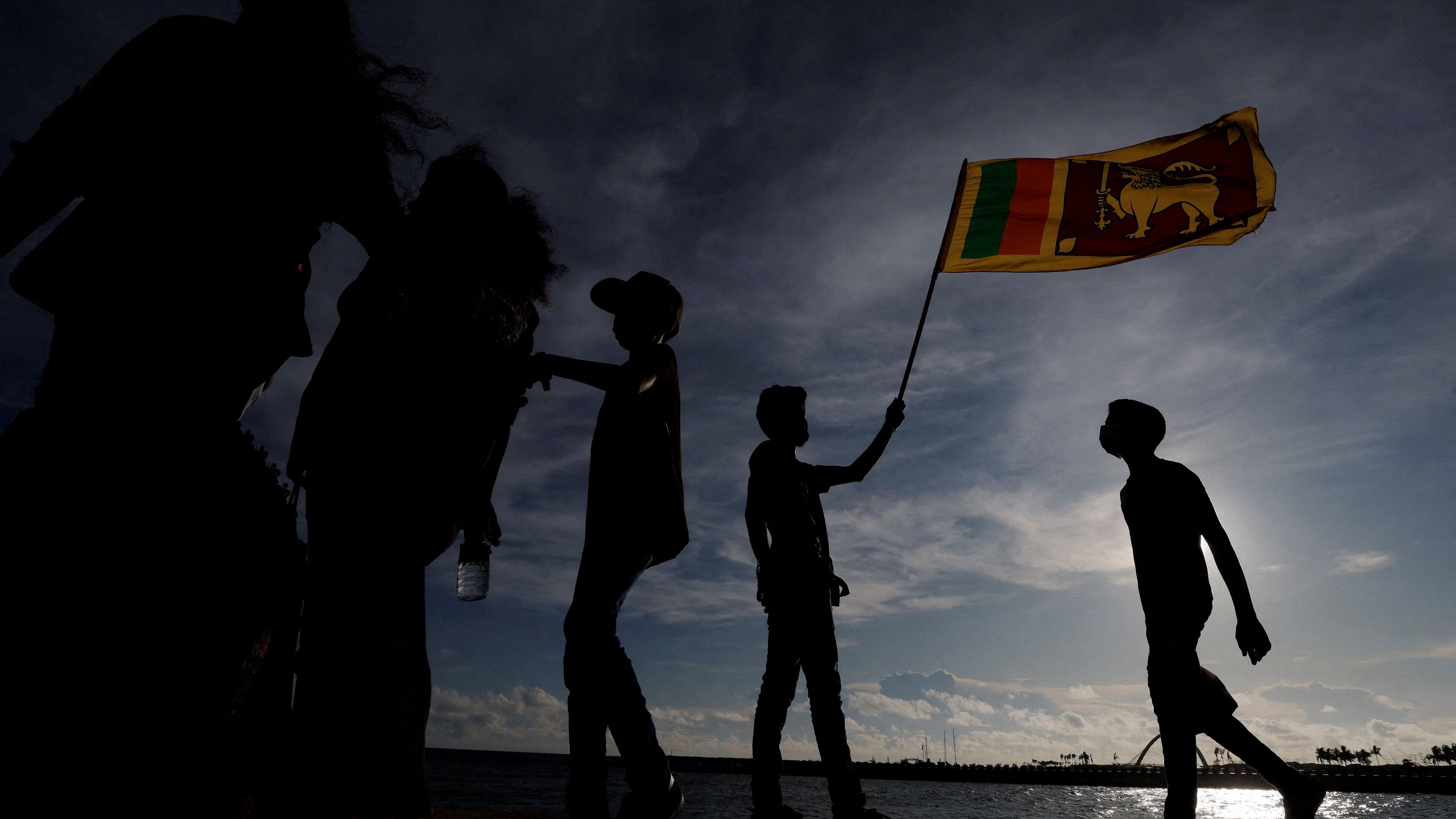 <div class="paragraphs"><p>Man holds a Sri Lankan national flag</p></div>