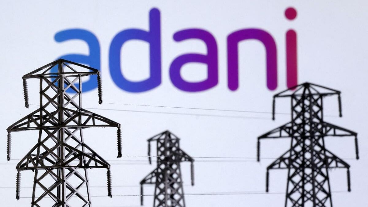 <div class="paragraphs"><p>Illustration shows Electric power transmission pylon miniatures and Adani Green Energy logo.</p></div>