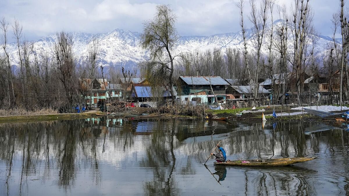 <div class="paragraphs"><p>A woman rows her boat across Dal Lake after fresh snowfall, in Srinagar. Image for representation only.</p></div>