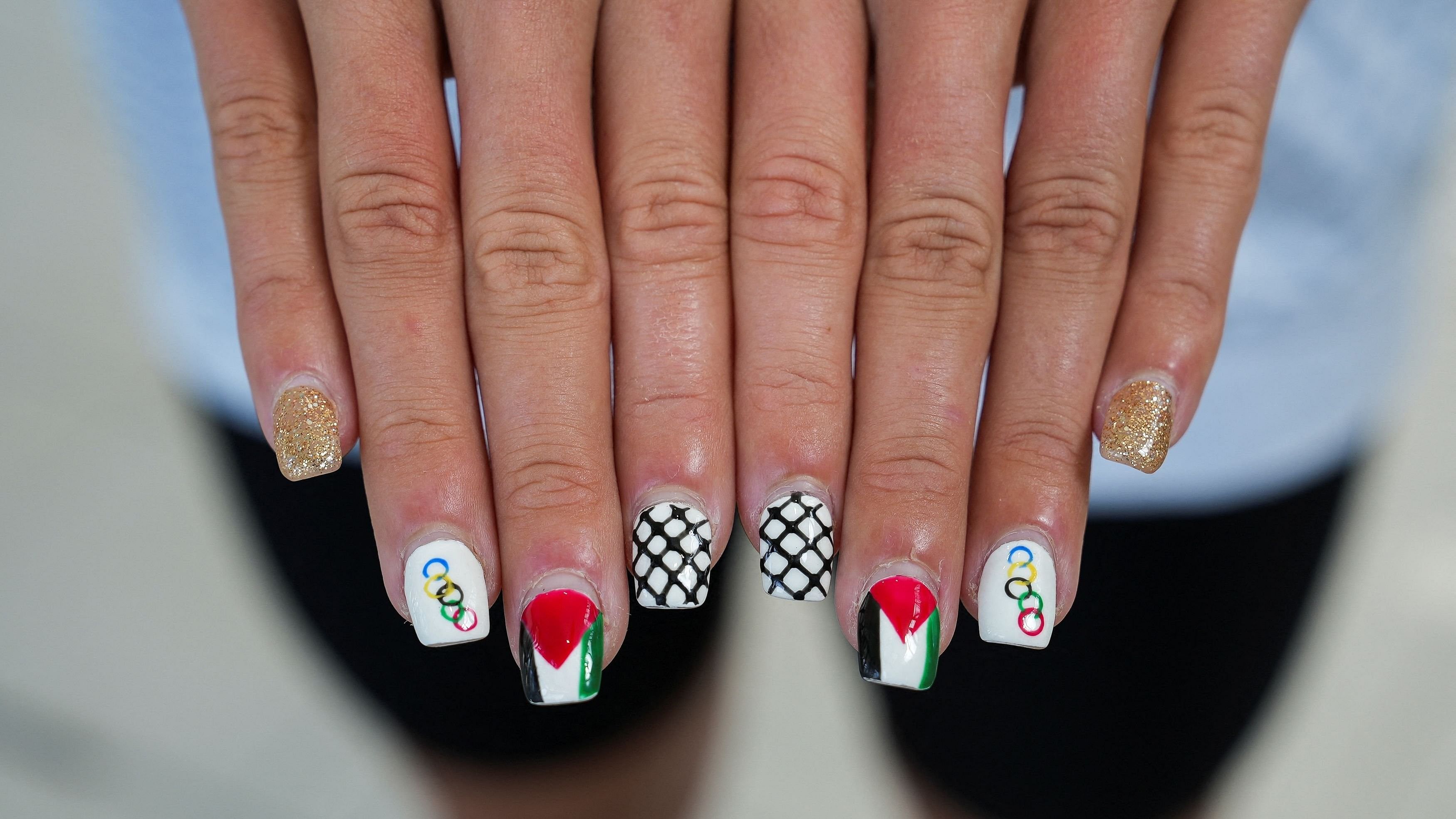 <div class="paragraphs"><p>Palestinian swimmer Valerie Tarazi shows off her fingernails painted with the Olympic rings, the Palestinian flag, and black and white checkers ahead of the Olympics in Paris, France July 20, 2024. </p></div>