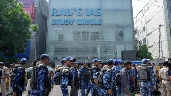 <div class="paragraphs"><p>Security personnel stand guard near a UPSC exam coaching centre after three civil services aspirants died when the basement of the coaching centre was flooded following heavy rain, in New Delhi.</p></div>