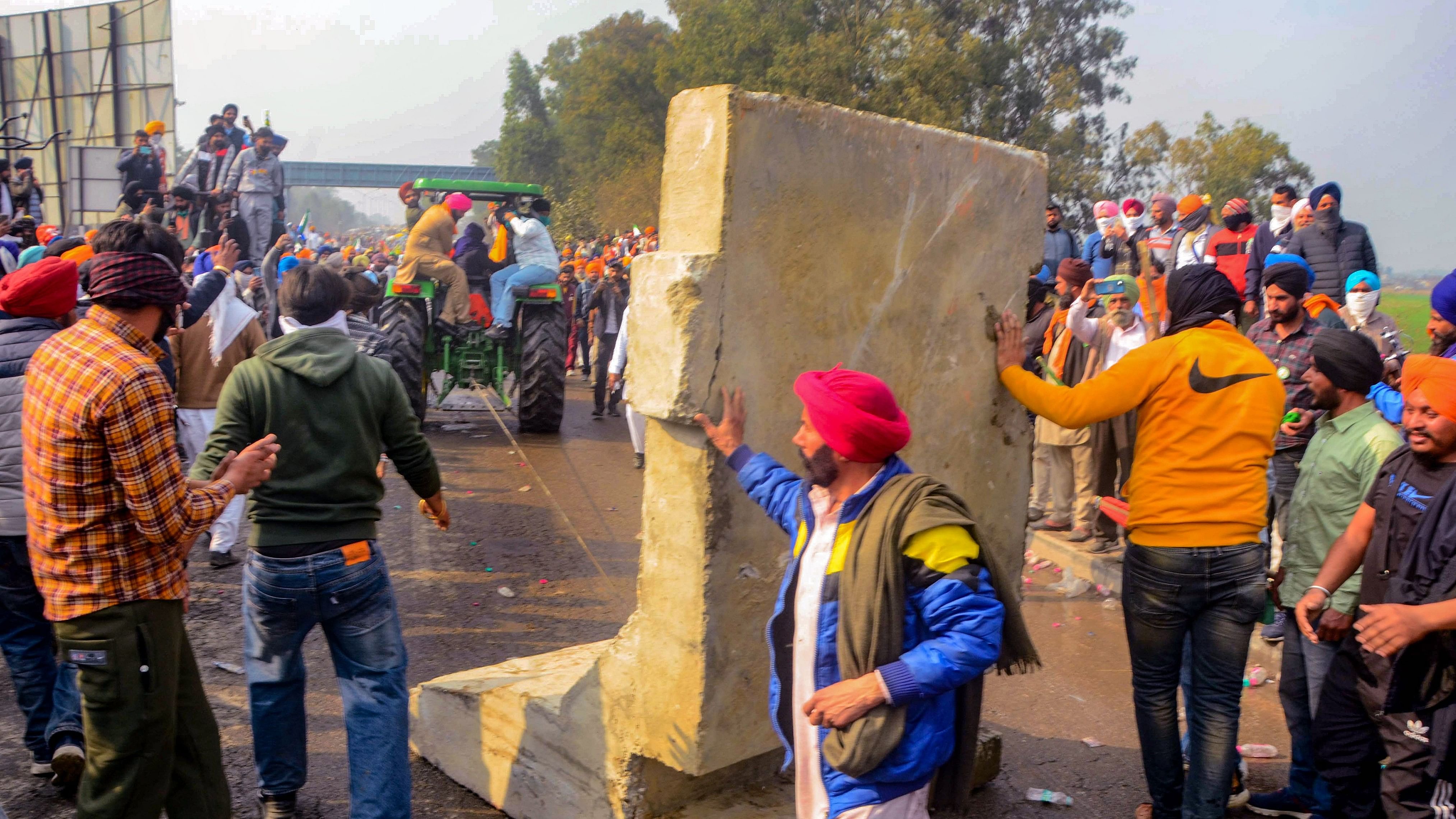 <div class="paragraphs"><p>Farmers try to remove barricades to cross the Punjab-Haryana Shambhu border during their 'Delhi Chalo' march, near Patiala.</p></div>