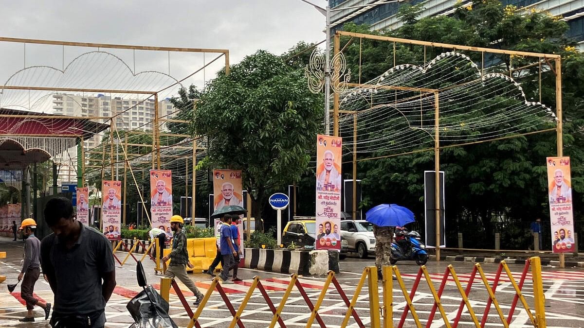 <div class="paragraphs"><p>People walk past posters of India's Prime Minister Narendra Modi outside Jio World Convention Centre, the wedding venue of Anant Ambani, son of Indian billionaire Mukesh Ambani, in Mumbai, India.</p></div>