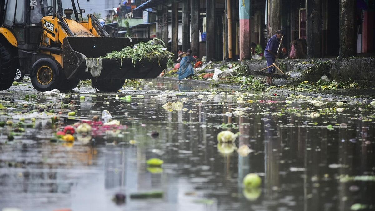 <div class="paragraphs"><p>Workers clear vegetables rotten due to heavy rains at the vegetables market in Mumbai.</p></div>