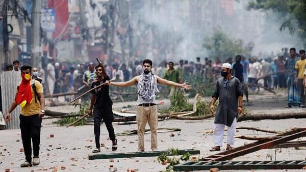 <div class="paragraphs"><p>A demonstrator gestures as protesters clash with Border Guard Bangladesh (BGB) and the police outside the state-owned Bangladesh Television as violence erupts across the country after anti-quota protests by students, in Dhaka, Bangladesh, July 19, 2024. </p></div>