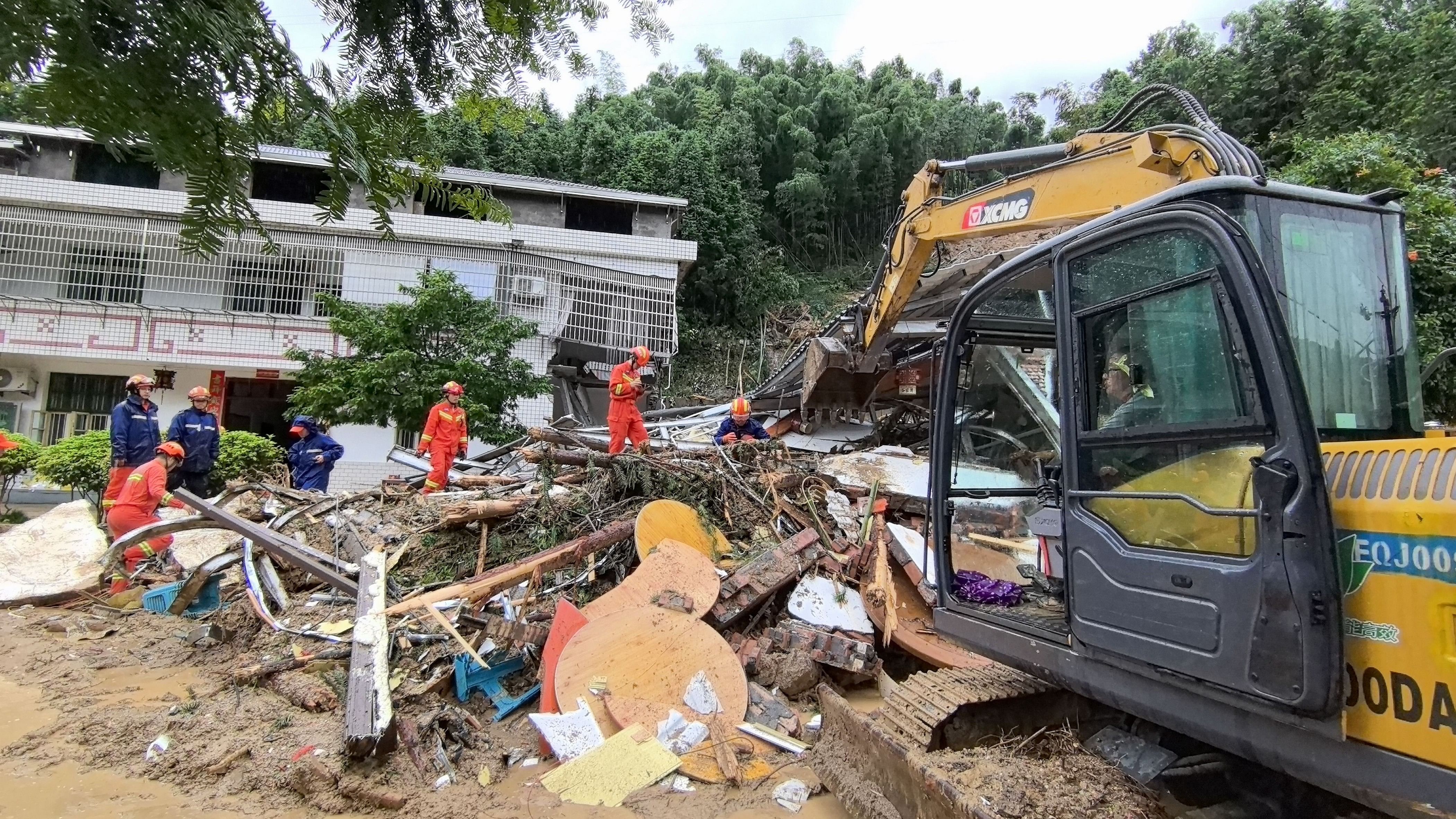 <div class="paragraphs"><p> A handout photo made available by the Fire and Rescue Department of Hunan shows rescuers working at a landslide-hit area in Yuelin village of Shouyue Town in Hengyang City, central China.  </p></div>