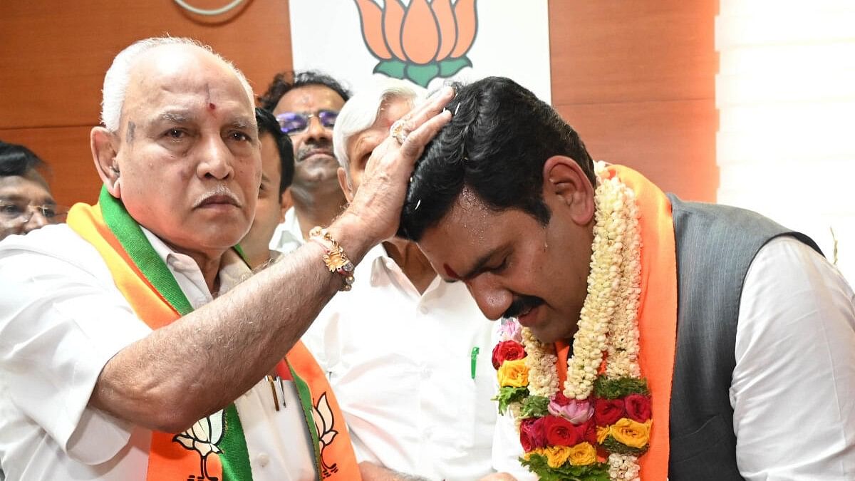 <div class="paragraphs"><p>File photo of B Y Vijayendra taking the blessings of his father B S Yediyurappa (L).</p></div>