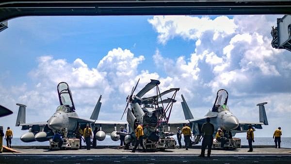 <div class="paragraphs"><p>US Navy sailors move aircraft from an elevator into the hangar bay of the aircraft carrier USS Theodore Roosevelt in the South China Sea in this file photo</p></div>