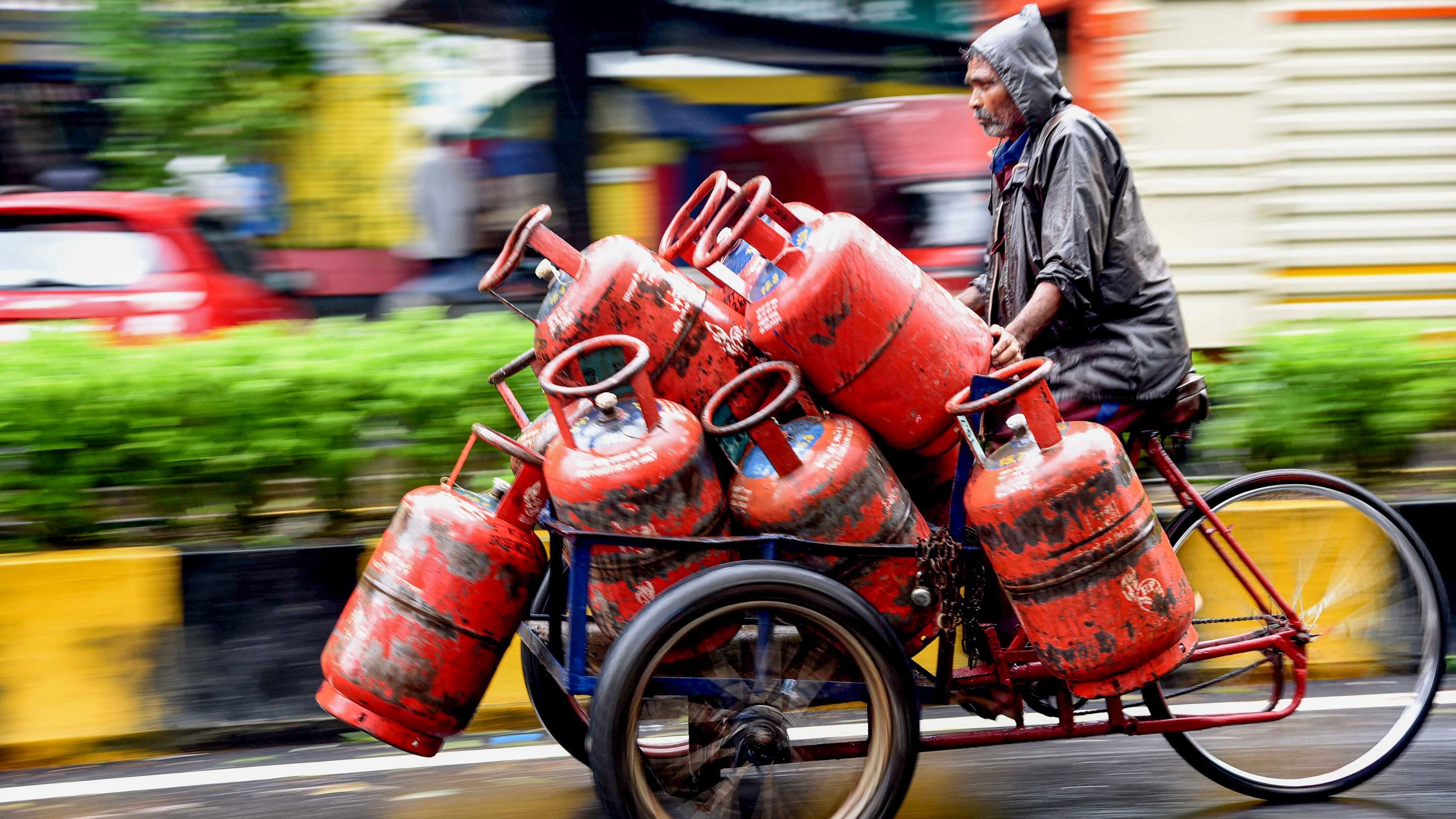 <div class="paragraphs"><p>A delivery man transports LPG cylinders on a cart amid monsoon rains.</p></div>