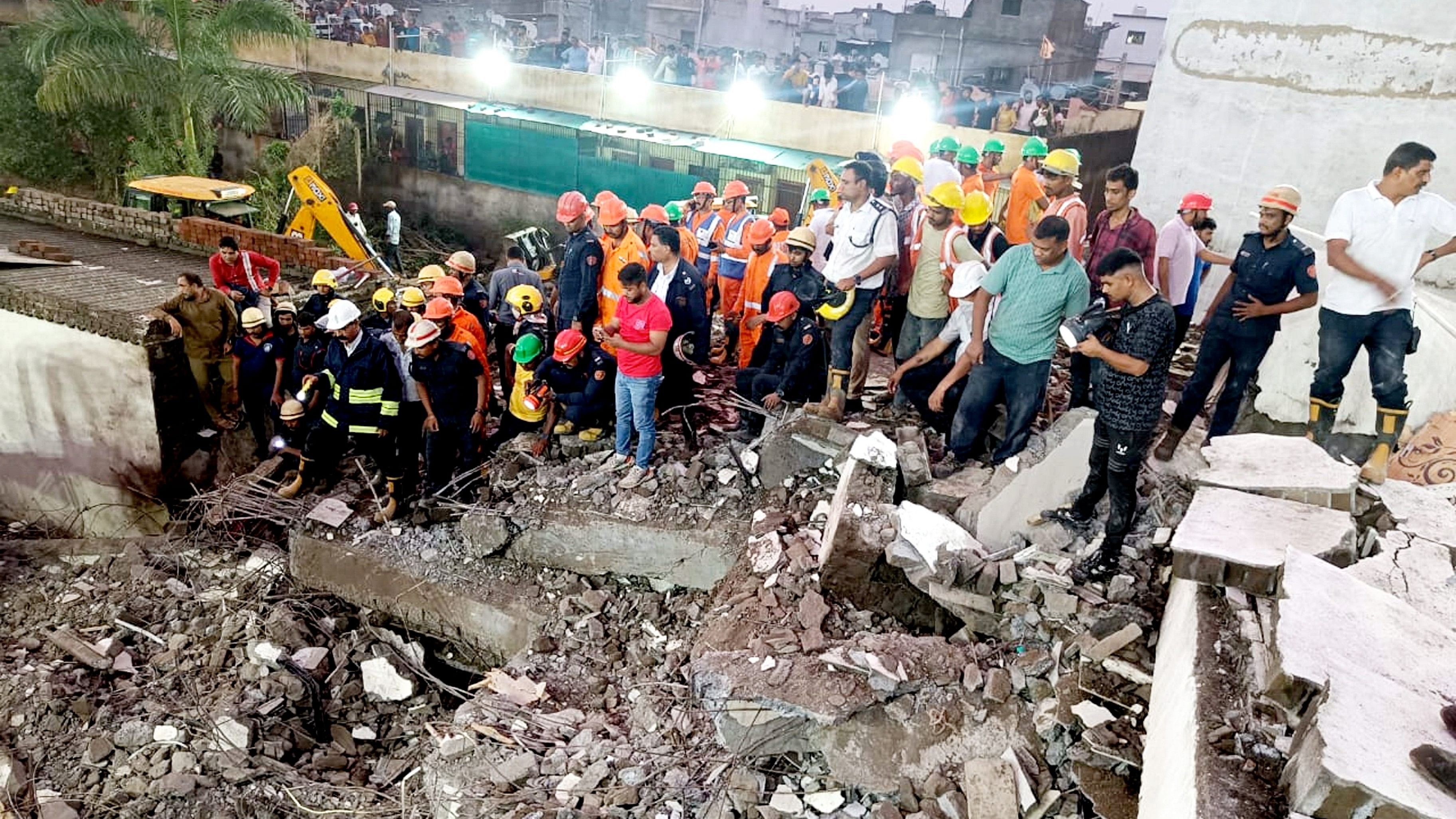 <div class="paragraphs"><p>Officials and others during a rescue operation after a building collapse, in Surat.</p></div>