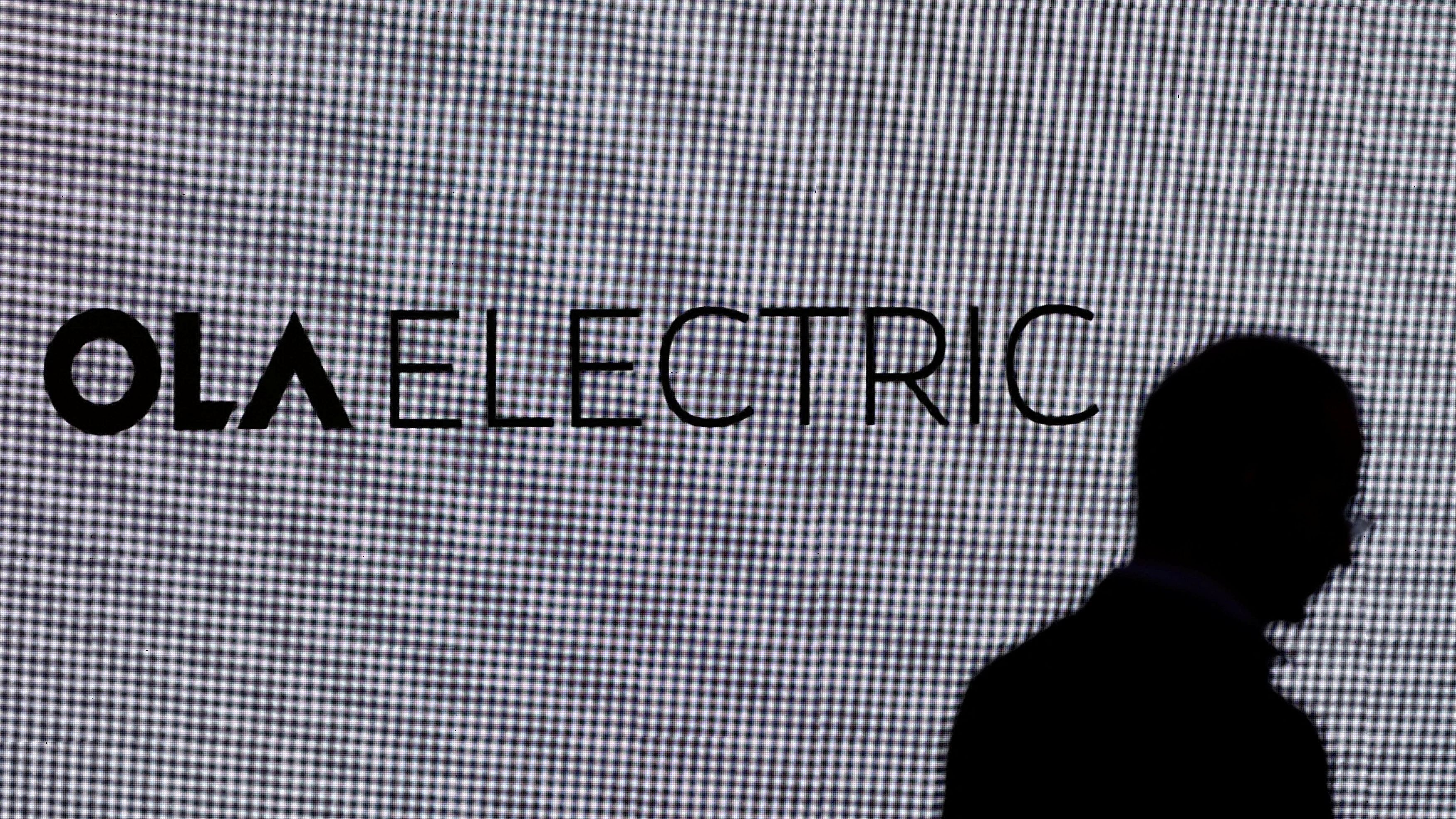 <div class="paragraphs"><p>A man walks past the logo of Ola Electric during a press conference ahead of it's IPO launch in Mumbai, India, July 29, 2024. </p></div>