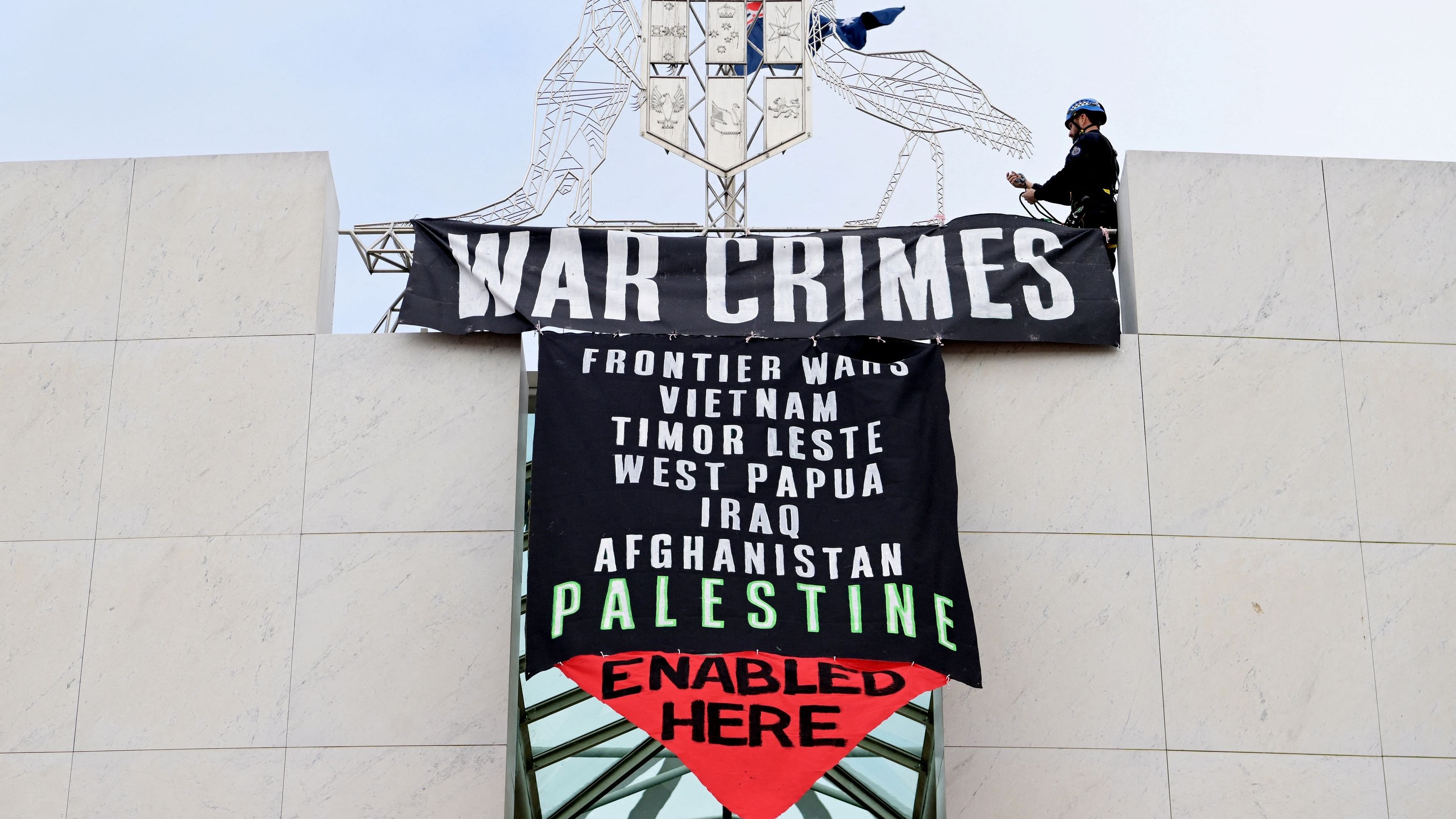 <div class="paragraphs"><p>An Australian Federal Police officer removes a Pro-Palestinian protest banner as it hangs in the forecourt of the Australian Parliament House, in Canberra, Australia, July 4, 2024.</p></div>