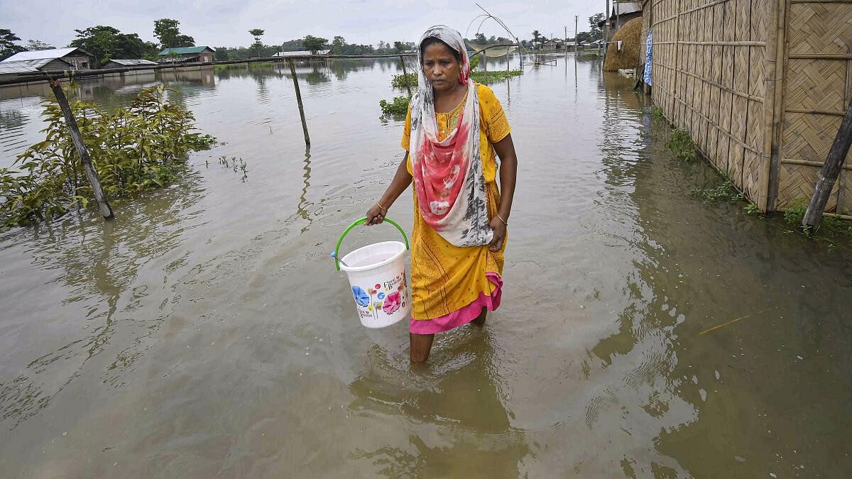 <div class="paragraphs"><p>A woman walks through a flood-affected area, in Nagaon district of Assam.</p></div>