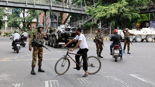 <div class="paragraphs"><p>Members of the Bangladesh Army gesture to commuters on the second day of curfew, as violence erupted in parts of the country after protests by students against government job quotas, in Dhaka, Bangladesh.</p></div>