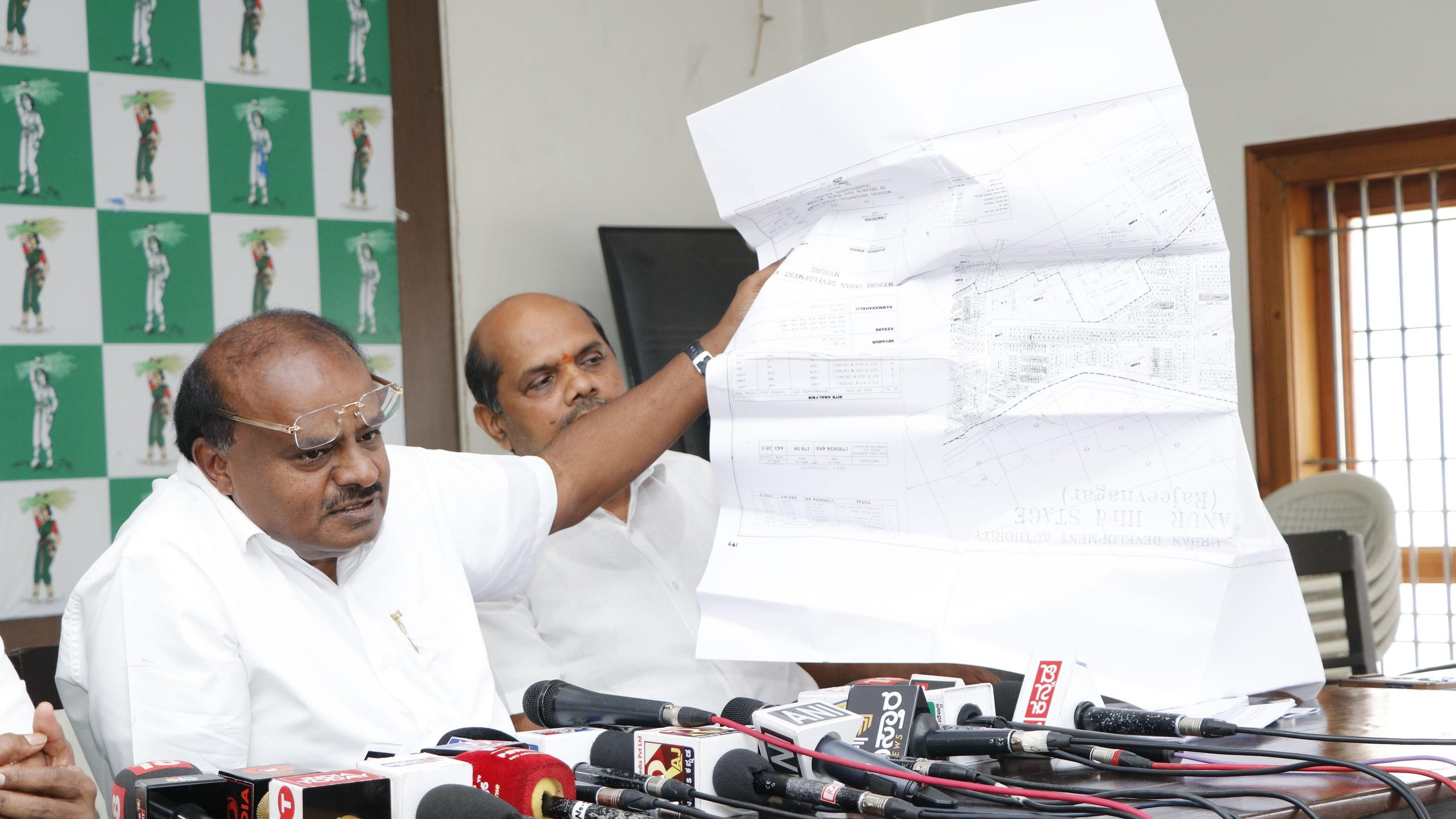 H D Kumaraswamy shows documents pertaining to the alleged MUDA scam at a presser in Bengaluru.