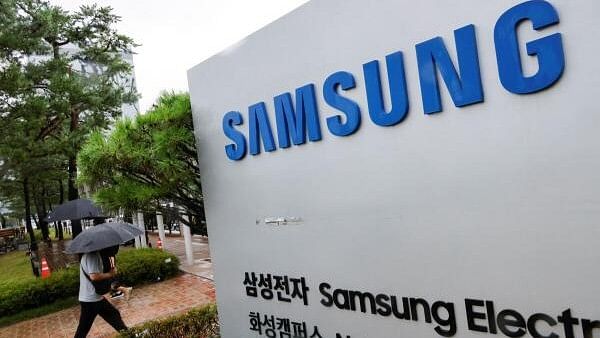 <div class="paragraphs"><p>A man walks past a signboard of Samsung Electronics in front of the Samsung Electronics Nano City Hwaseong Campus in Hwaseong, South Korea.</p></div>