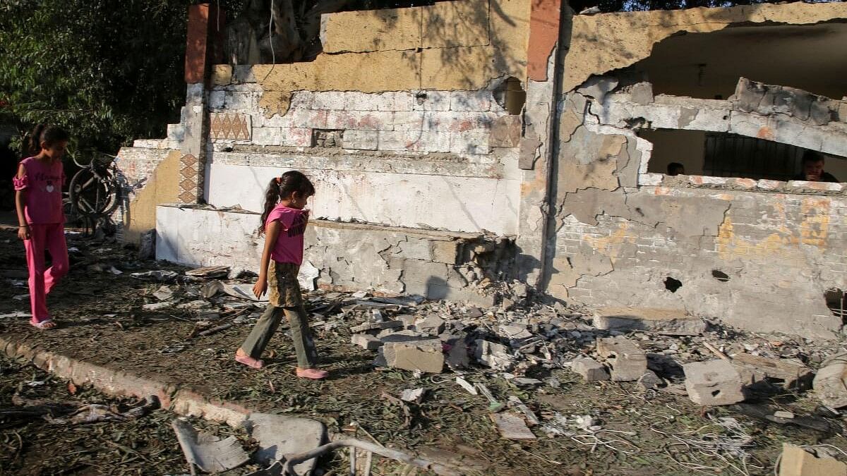 <div class="paragraphs"><p>Palestinian girls walk at the site of an Israeli strike, outside a school sheltering displaced people, amid Israel-Hamas conflict, in Khan Younis in the southern Gaza Strip.</p></div>