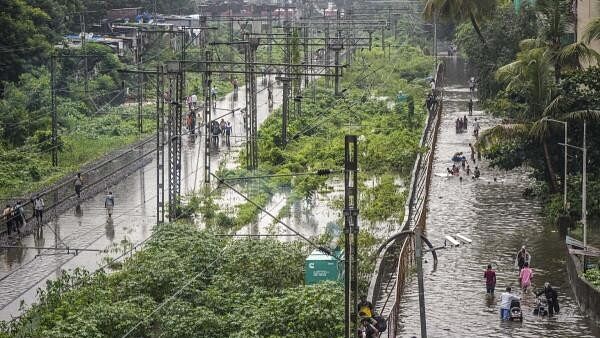 <div class="paragraphs"><p>People make their way through a waterlogged street following rains, in Mumbai, Monday, July 8, 2024. </p></div>