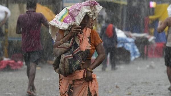 <div class="paragraphs"><p>A woman protects herself from rains, in New Delhi, Monday, July 15, 2024.</p></div>