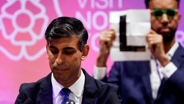 <div class="paragraphs"><p>Independent candidate Niko Omilana holds an "L" sign behind British Prime Minister Rishi Sunak as he speaks after winning his seat at Richmond and Northallerton during the UK election in Northallerton, Britain, July 5, 2024.&nbsp;</p></div>