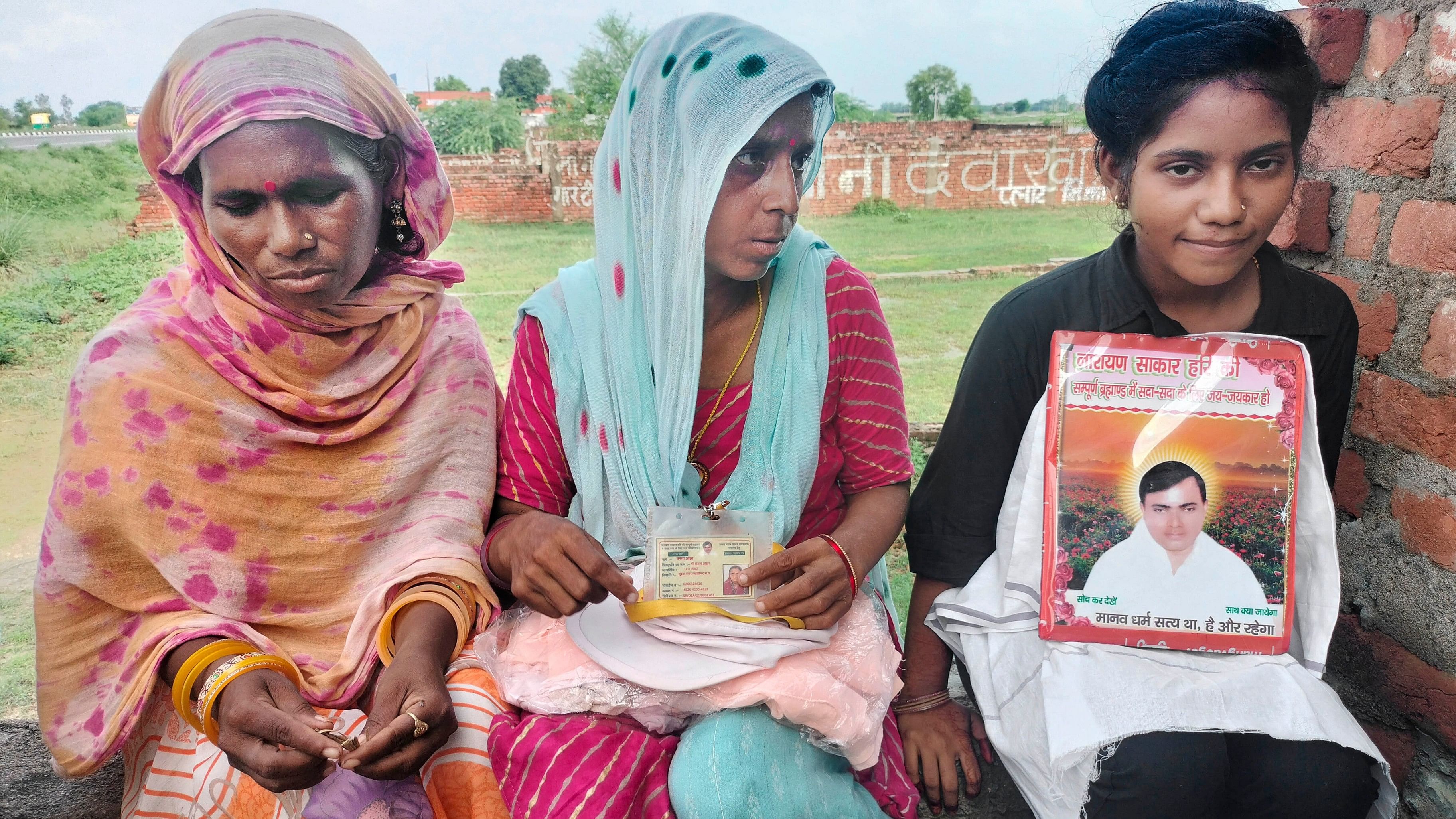 <div class="paragraphs"><p>Devotees sit with a picture of preacher Suraj Pal alias  Sakar Hari alias Bhole Baba at his 'ashram'.</p></div>