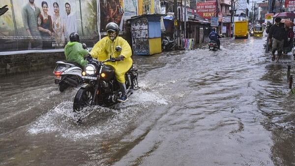 <div class="paragraphs"><p>File photo of people commuting amid heavy rainfall in Kerala.</p></div>