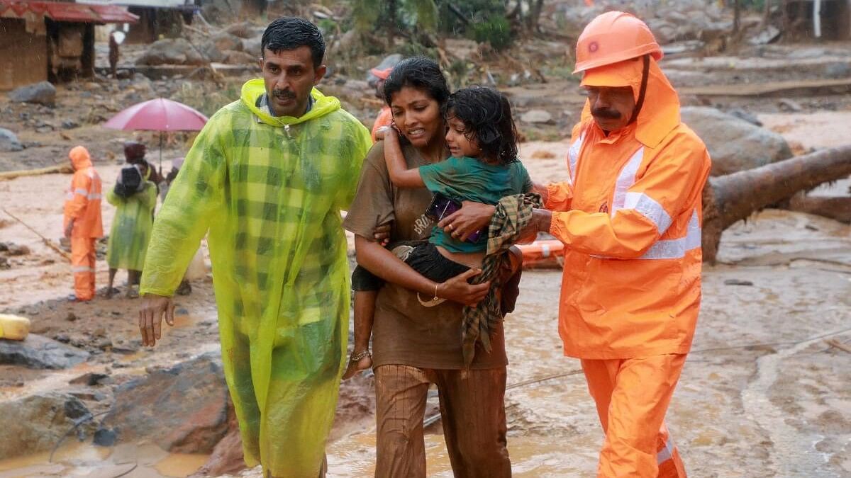 <div class="paragraphs"><p>Rescuers help residents to move to a safer place, at a landslide site after multiple landslides in the hills, in Wayanad, in the southern state of Kerala, July 30, 2024.</p></div>