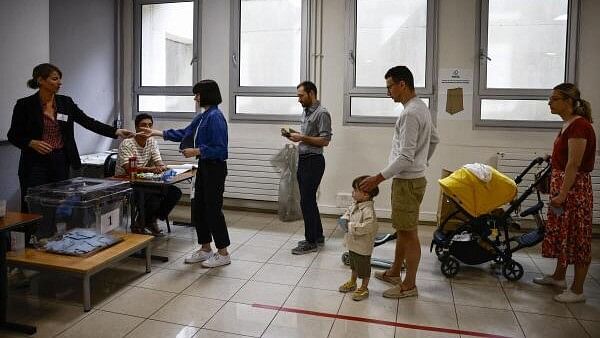 <div class="paragraphs"><p>People queue to vote in the second round of the early French parliamentary elections, at a polling station in Paris, France, July 7, 2024. </p></div>