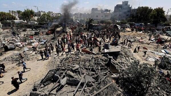 <div class="paragraphs"><p>Palestinians gather near a damage site, following what Palestinians say was an Israeli strike at a tent camp in Al-Mawasi area, amid Israel-Hamas conflict in Khan Younis in the southern Gaza Strip on July 13, 2024.</p></div>