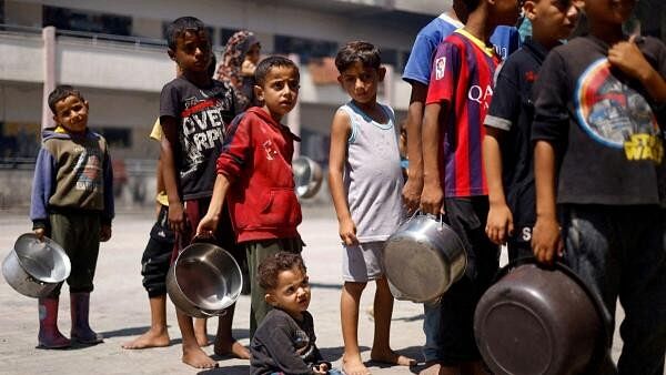 <div class="paragraphs"><p>Palestinians gather to receive food cooked by a charity kitchen, amid food scarcity, as Israel-Hamas conflict continues, in Khan Younis in the southern Gaza Strip</p></div>