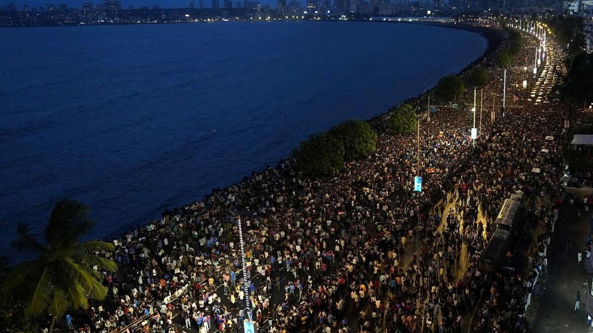 <div class="paragraphs"><p>Fans gather along the Marine Drive as the Indian cricket team members take part in a parade to celebrate winning the ICC men's T20 World Cup, in Mumbai.</p></div>