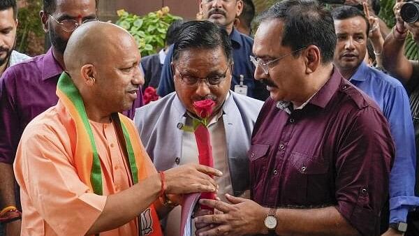 <div class="paragraphs"><p>Uttar Pradesh Chief Minister Yogi Adityanath being received by Delhi BJP President Virendra Sachdeva and others upon his arrival for a meeting at BJP headquarters, in New Delhi, Saturday.&nbsp;</p></div>