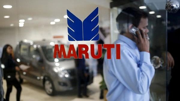 <div class="paragraphs"><p>A man speaks on his mobile phone as he exits a glass door with the logo of Maruti Suzuki India Limited at a showroom in New Delhi</p></div>