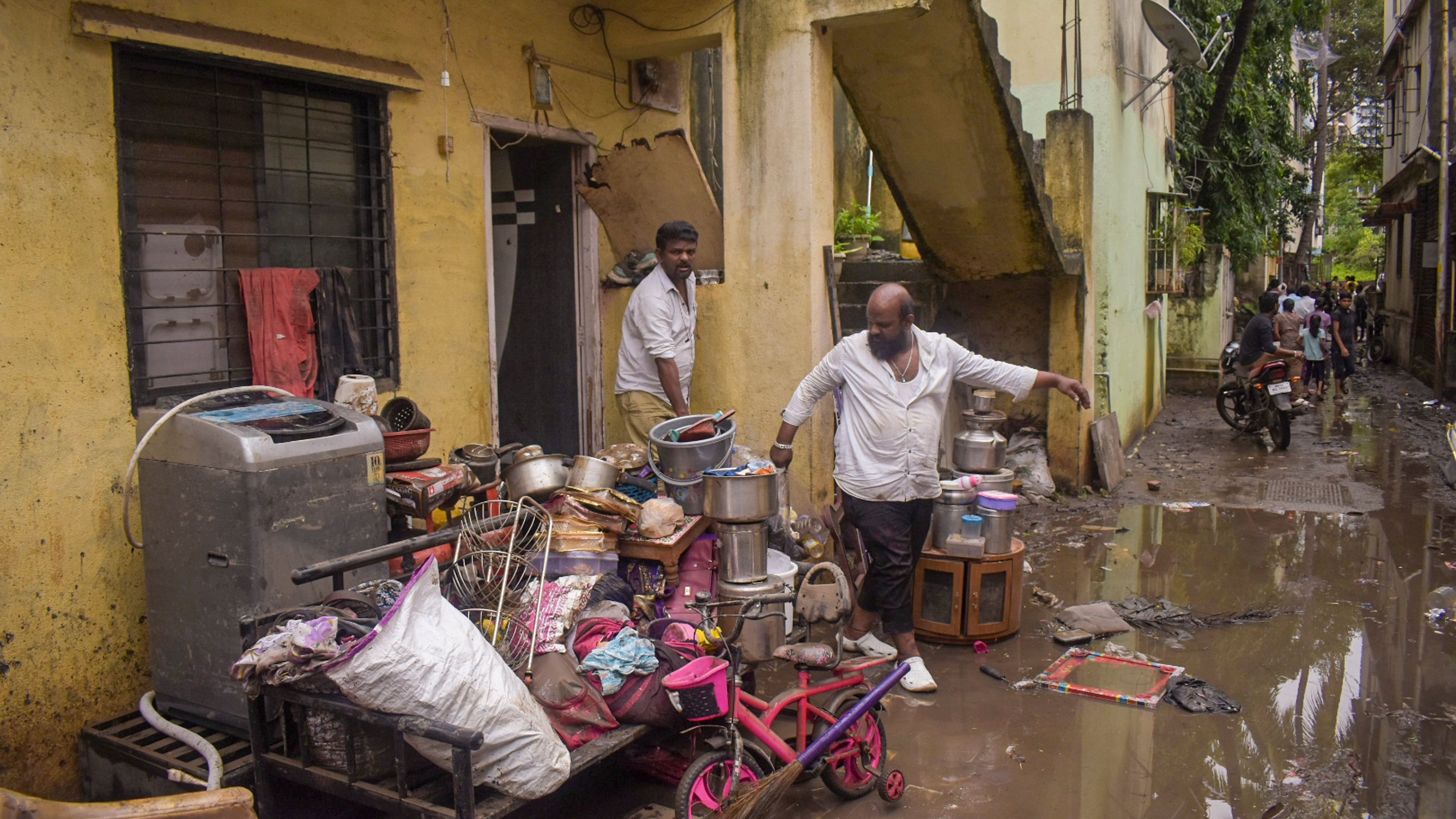 <div class="paragraphs"><p> People move their belongings in the aftermath of heavy rainfall.</p></div>