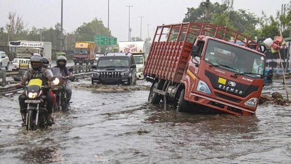 <div class="paragraphs"><p>Vehicles move through waterlogged Delhi-Gurugram Expressway service road after heavy rains, in Gurugram.</p></div>
