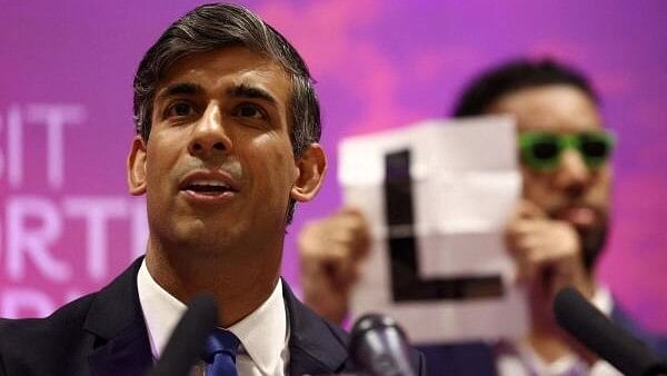 <div class="paragraphs"><p>Independent candidate Niko Omilana holds an "L" behind Britain's Prime Minister and Conservative Party leader Rishi Sunak</p></div>