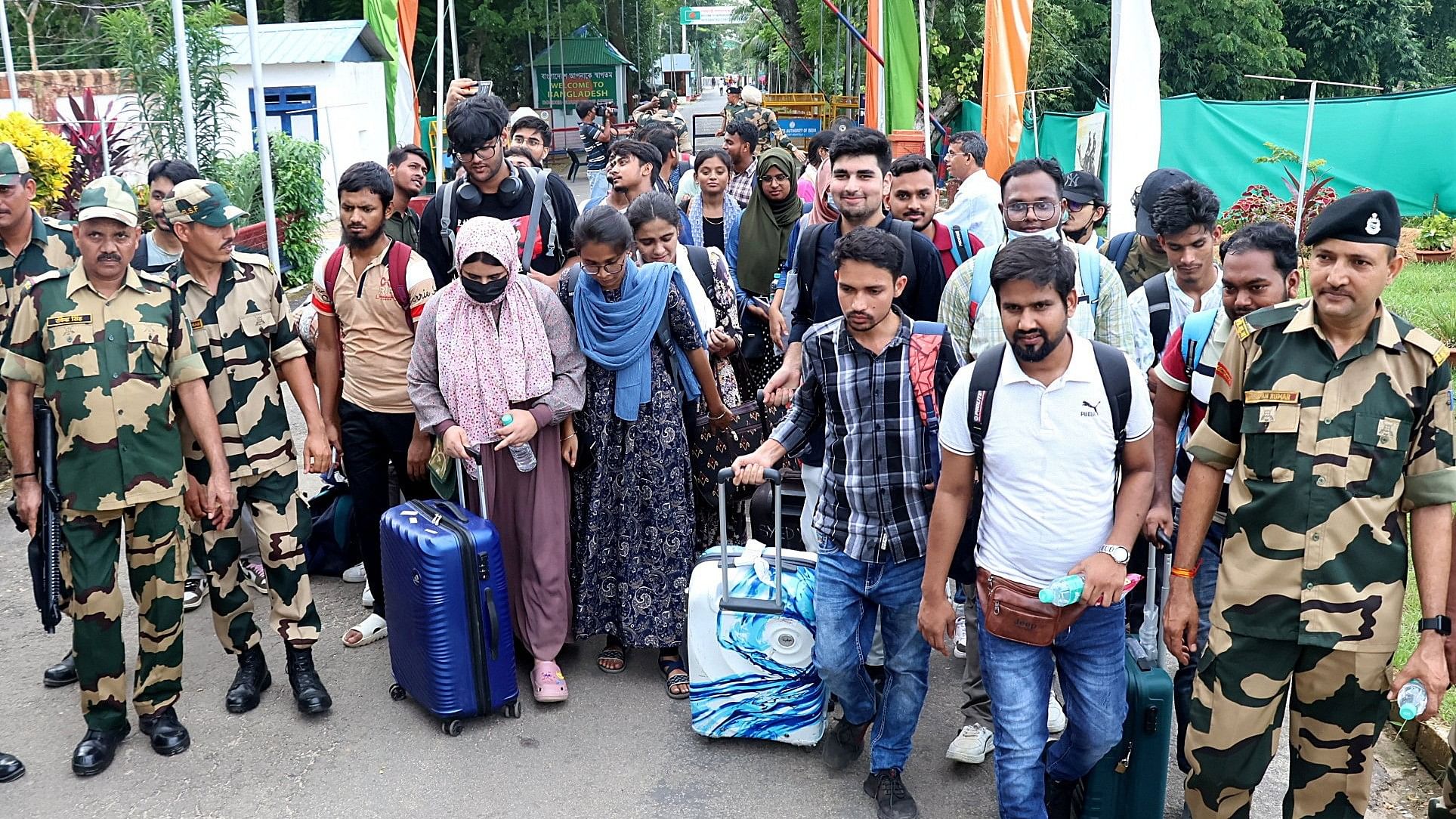 <div class="paragraphs"><p>Members of India's Border Security Force escort Indian students, who study in Bangladesh, after they crossed over at the Akhaura check post of the India-Bangladesh border in the northeastern Indian state of Tripura, following protests against government job quotas in Bangladesh.</p></div>