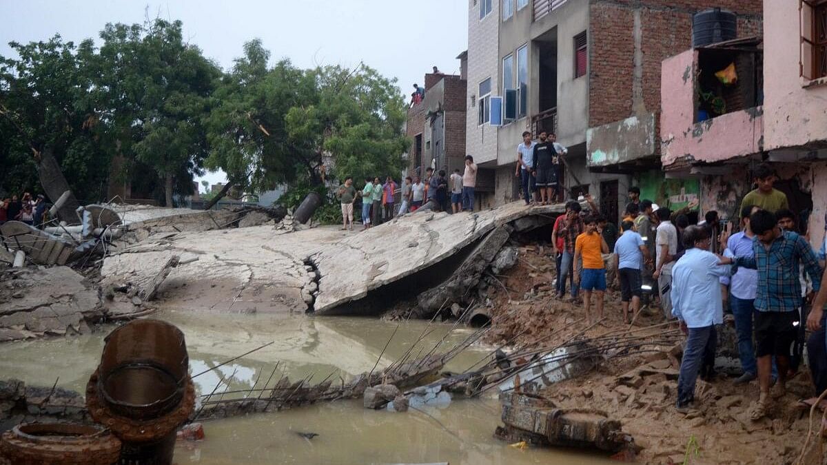 <div class="paragraphs"><p>People near the debris after a water tank collapsed due to heavy rainfall, in Mathura, Sunday, June 30, 2024.</p></div>