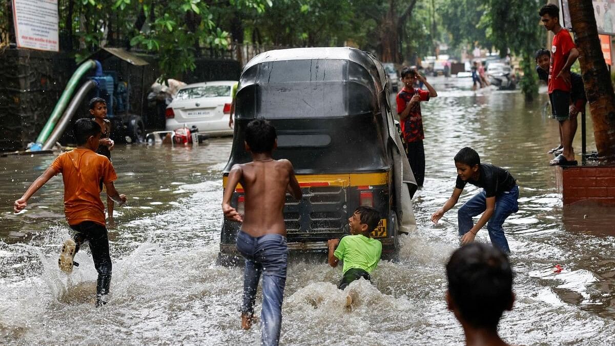 <div class="paragraphs"><p>A boy clings to an auto rickshaw on a waterlogged street after heavy rains in Mumbai.</p><p></p></div>