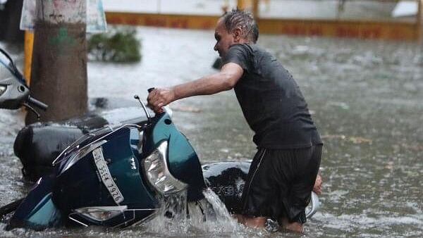 <div class="paragraphs"><p>A man stuck with his scooter on a waterlogged road amid rains, in New Delhi.</p></div>