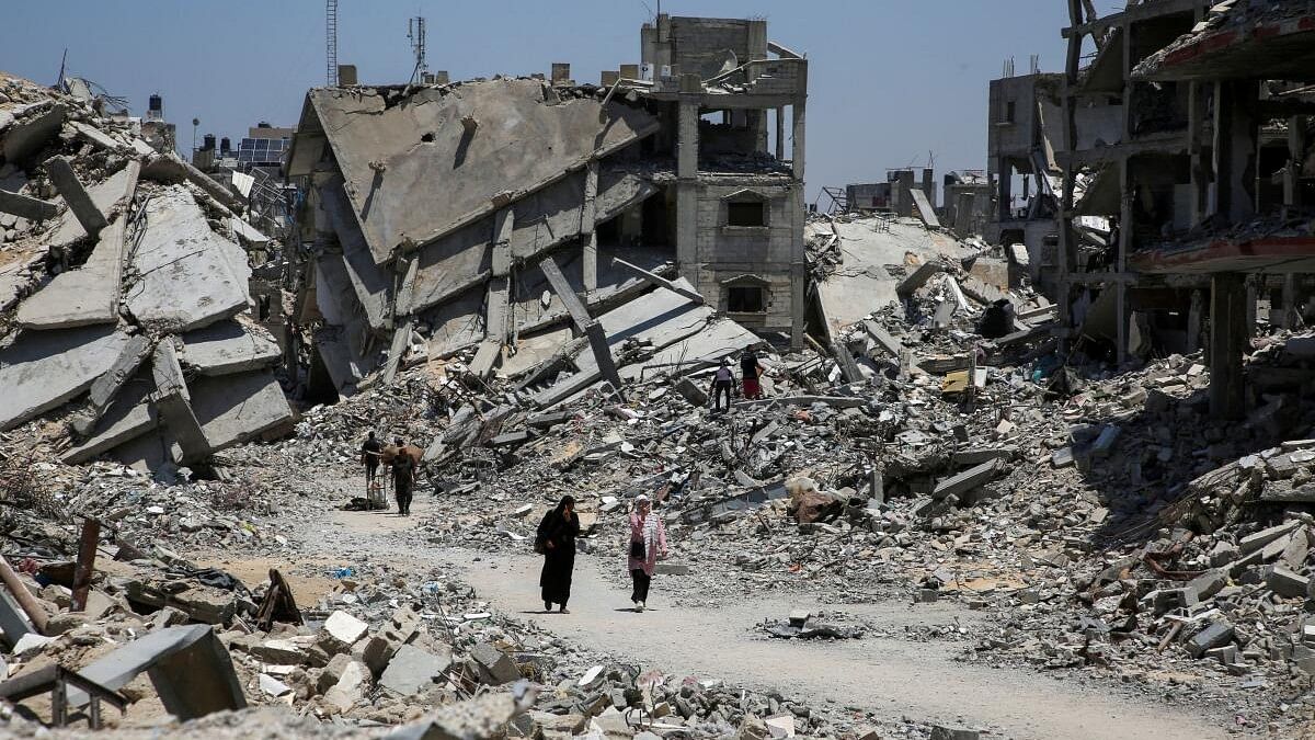 <div class="paragraphs"><p>Palestinians walk past the rubble of houses destroyed during the Israeli military offensive, amid Israel-Hamas conflict, in Khan Younis in the southern Gaza Strip.</p></div>