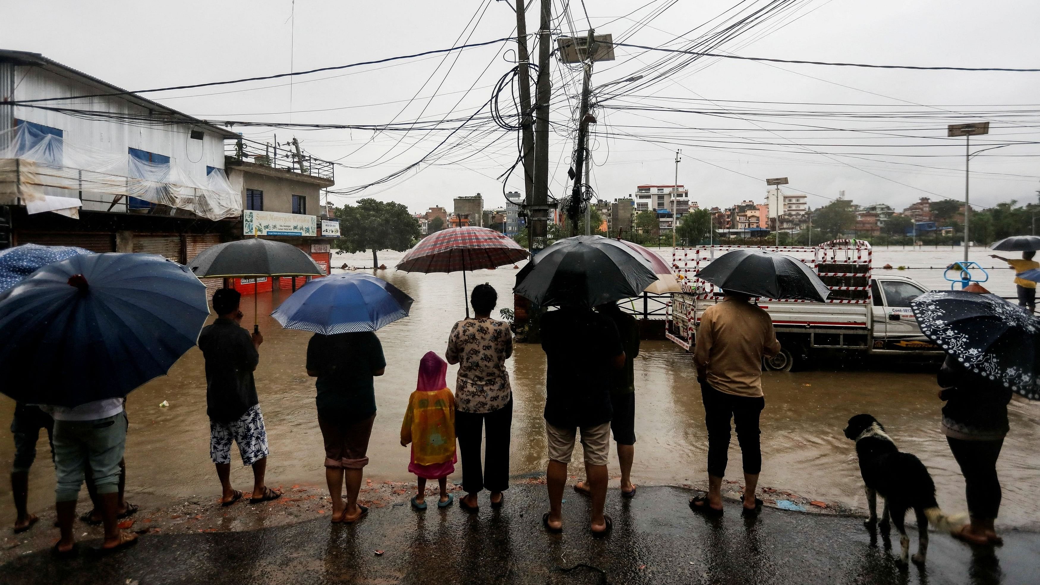 <div class="paragraphs"><p>People look towards a flooded area along the bank of overflowing Bagmati River following heavy rains in Kathmandu, Nepal, July 6, 2024.</p></div>