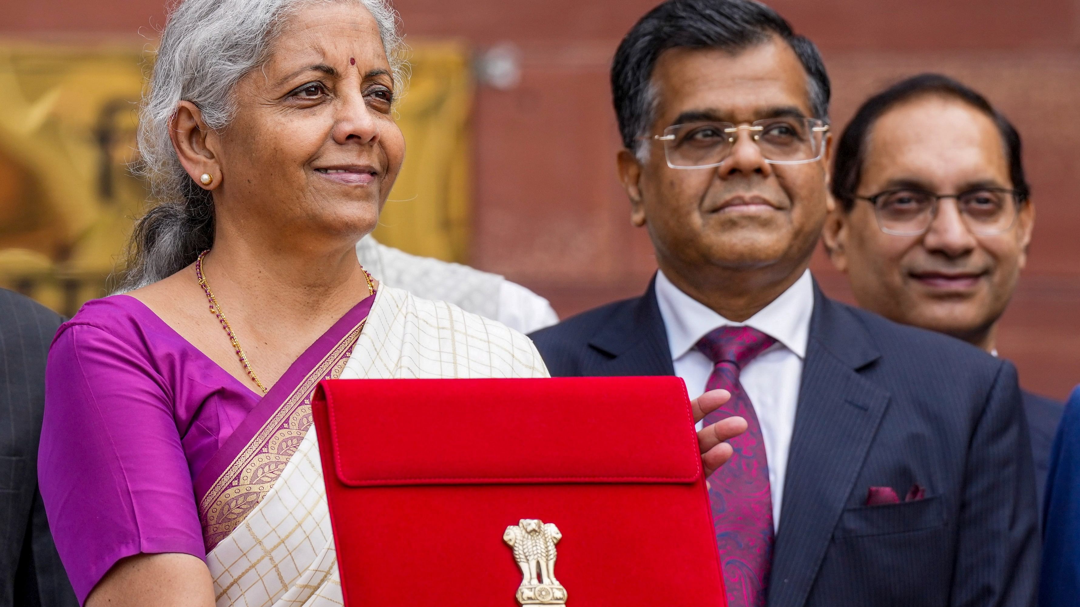 <div class="paragraphs"><p>Union Finance Minister Nirmala Sitharaman along with Finance Secretary T V Somanathan displays a red pouch carrying the Budget documents</p></div>