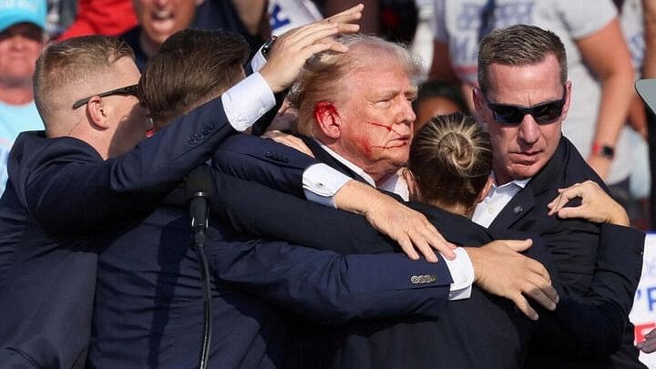 <div class="paragraphs"><p>Republican presidential candidate and former US President Donald Trump gestures with a bloodied face as he is assisted by security personnel after multiple shots rang out during a campaign rally at the Butler Farm Show in Butler, Pennsylvania, US.</p></div>