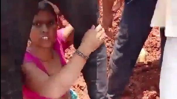 <div class="paragraphs"><p>Screengrab of video showing woman holding on to a man's leg after they were buried</p></div>