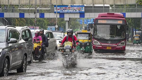 <div class="paragraphs"><p>Commuters wade through a waterlogged road during rains, near ITO, in New Delhi, Tuesday, July 9, 2024. </p></div>