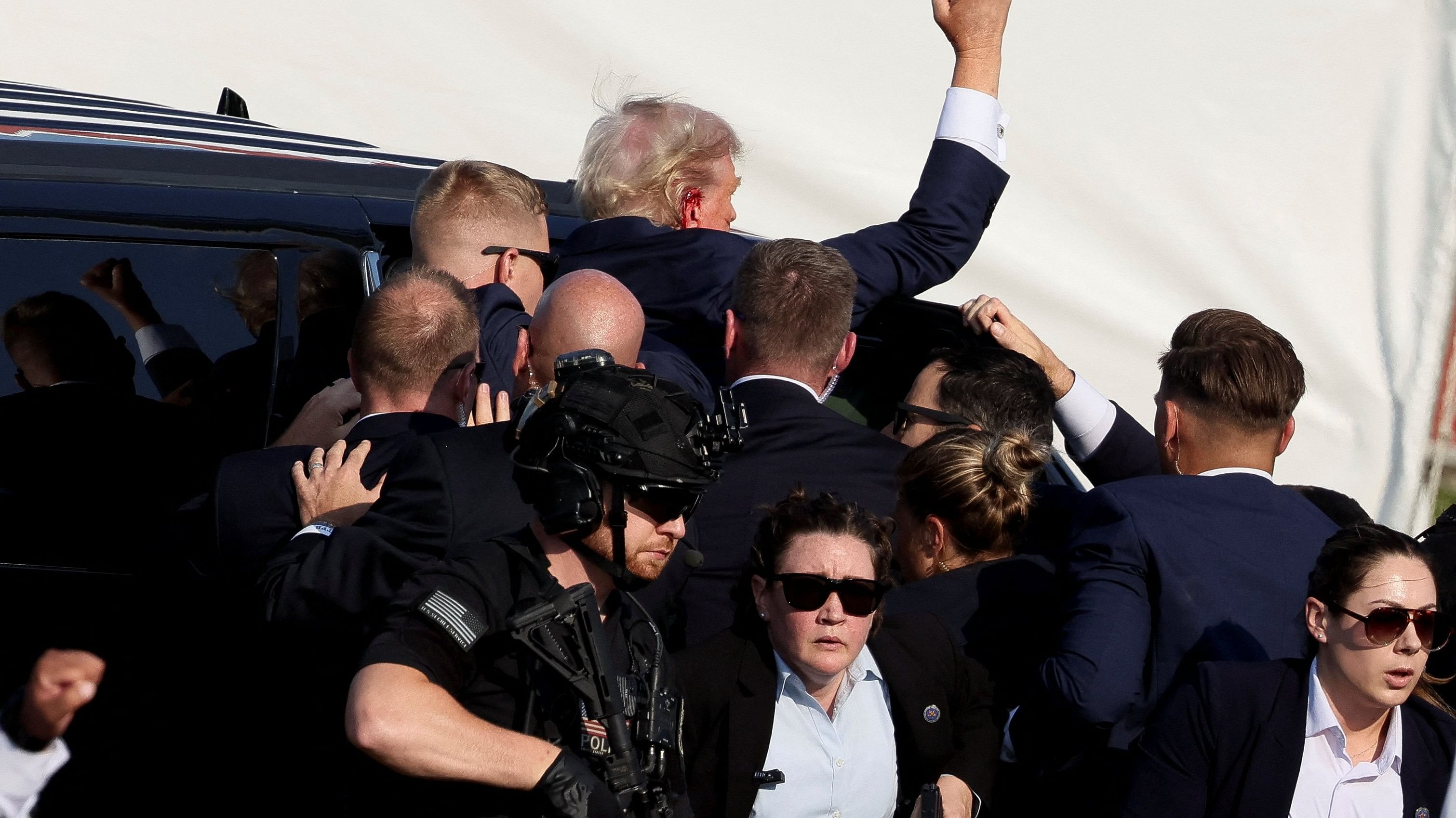 <div class="paragraphs"><p>Republican presidential candidate and former US President Donald Trump gestures as he gets into a vehicle with the assistance of US Secret Service personnel after he was shot in the right ear during a campaign rally at the Butler Farm Show in Butler, Pennsylvania, U.S., July 13, 2024. </p></div>