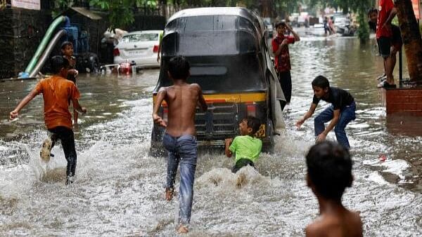 <div class="paragraphs"><p>A boy clings to an auto rickshaw on a waterlogged street after heavy rains in Mumbai, India, July 8, 2024. </p></div>