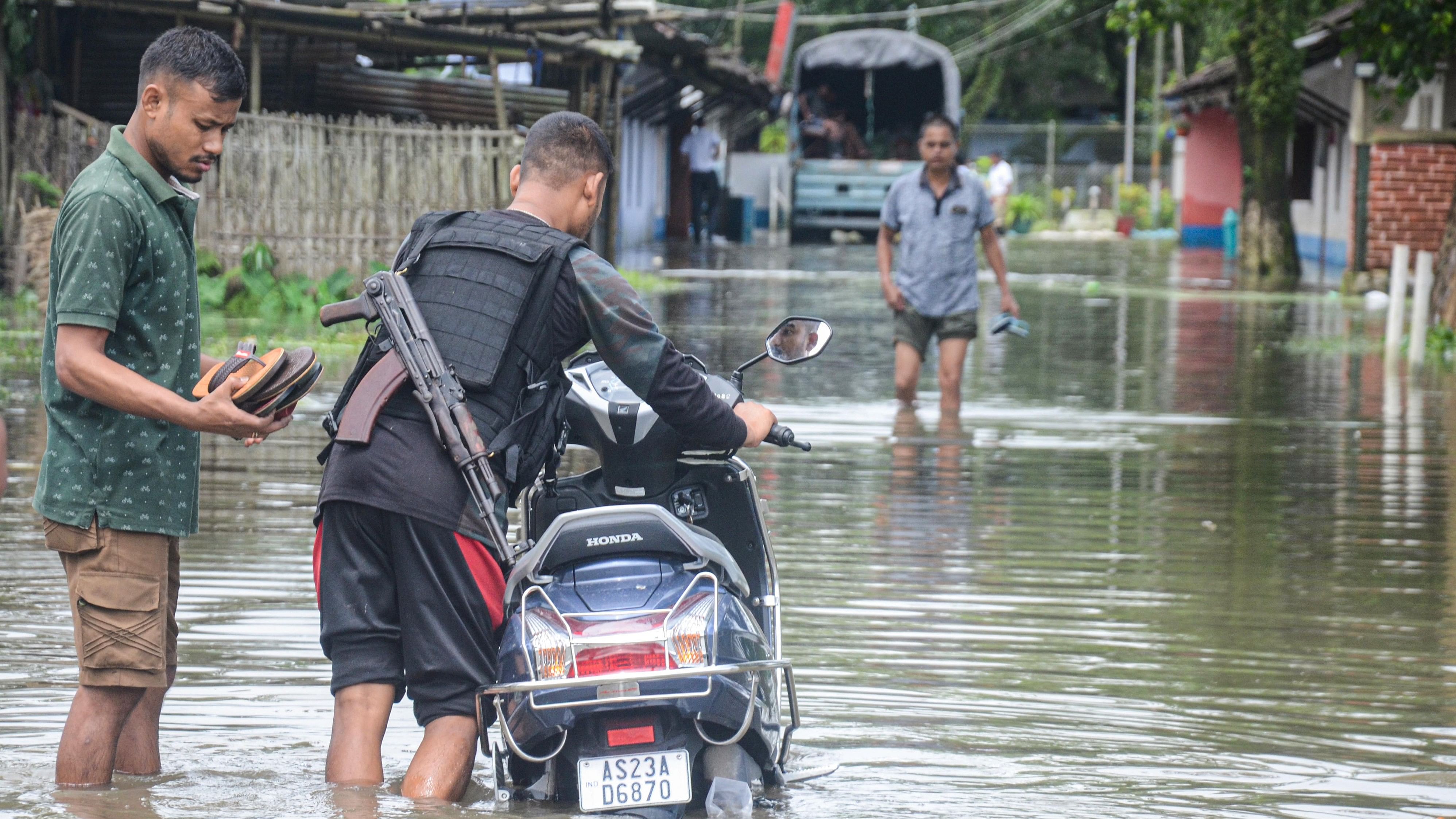 <div class="paragraphs"><p> A policeman pushes his two-wheeler through a flooded road, in Dibrugarh, Friday, July 1, 2022. </p></div>