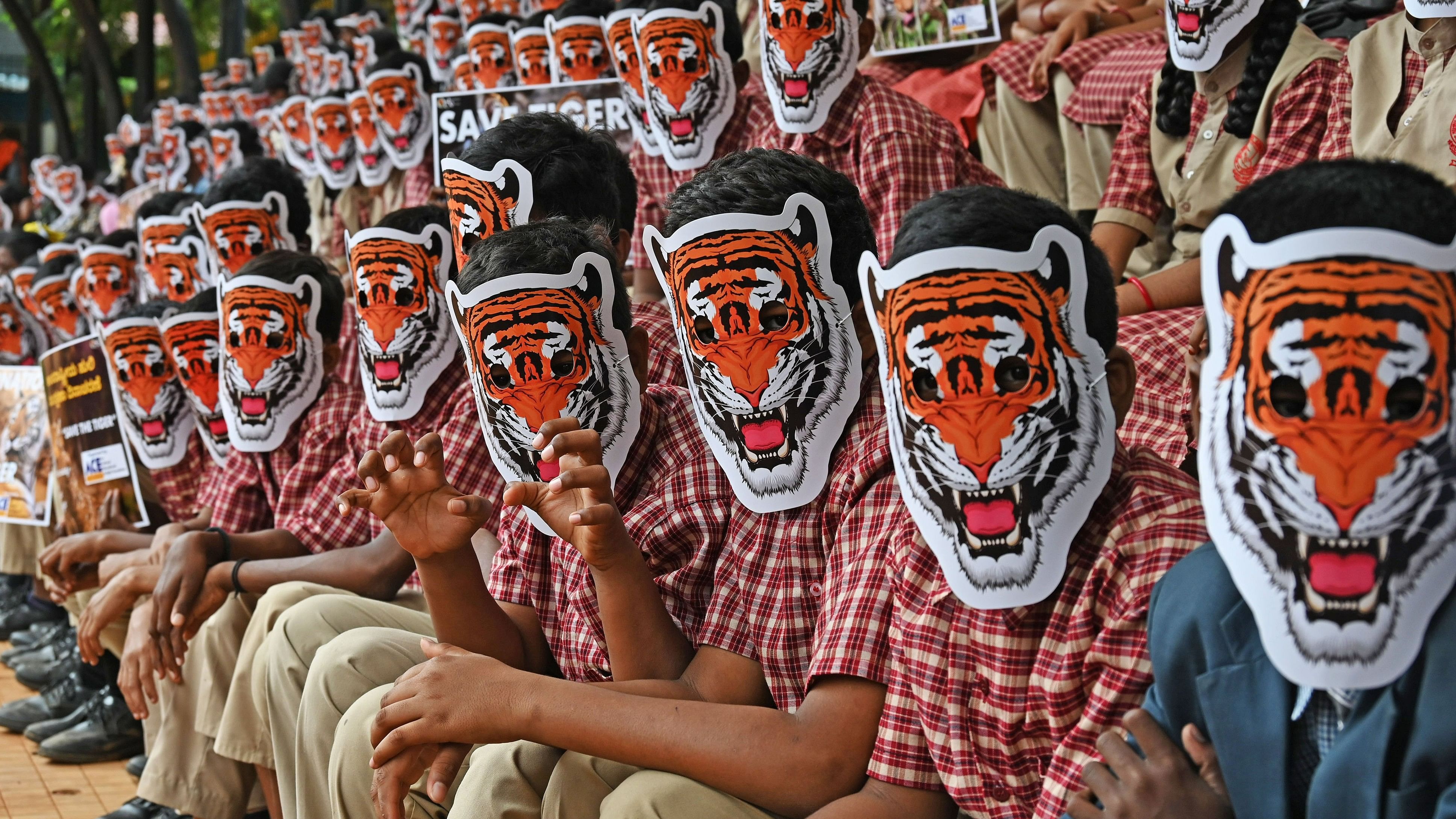 <div class="paragraphs"><p>Students wear tiger masks as they participate in an event to mark 'International Tiger Day' on Monday. </p></div>